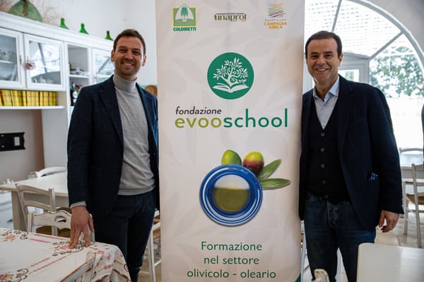Due persona davanti allo standing della fondazione Evooschool.