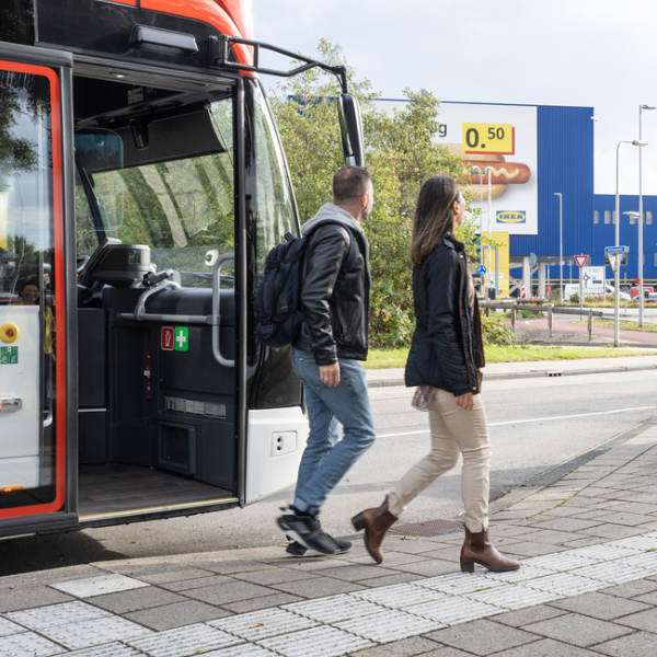 Due persone che scendono da un autobus e camminano verso l'ingresso di un negozio IKEA.