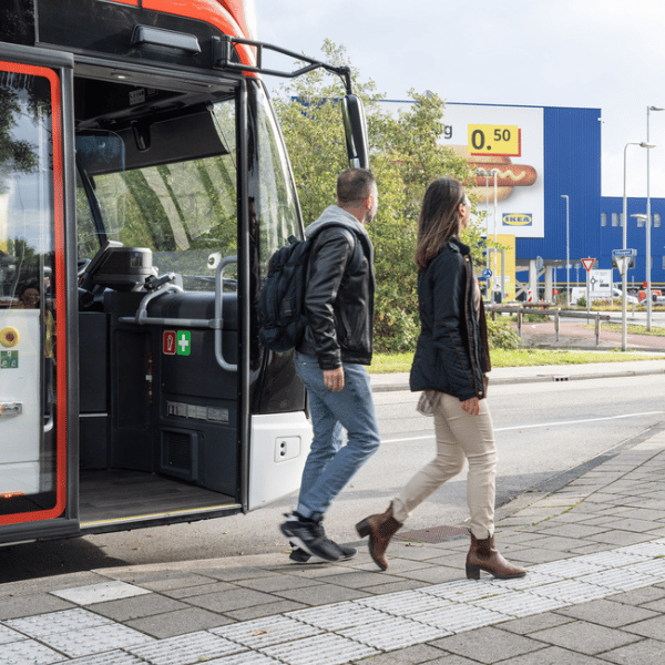 Due persone che scendono da un autobus e camminano verso l'ingresso di un negozio IKEA.