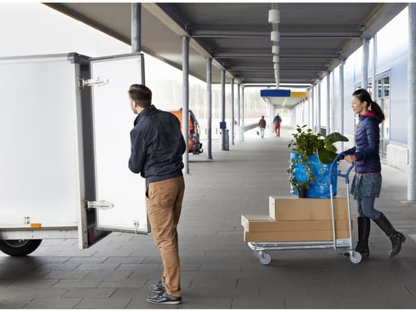 Due persone che stanno caricando i loro acquisti su un furgone a noleggio fuori dal negozio. 