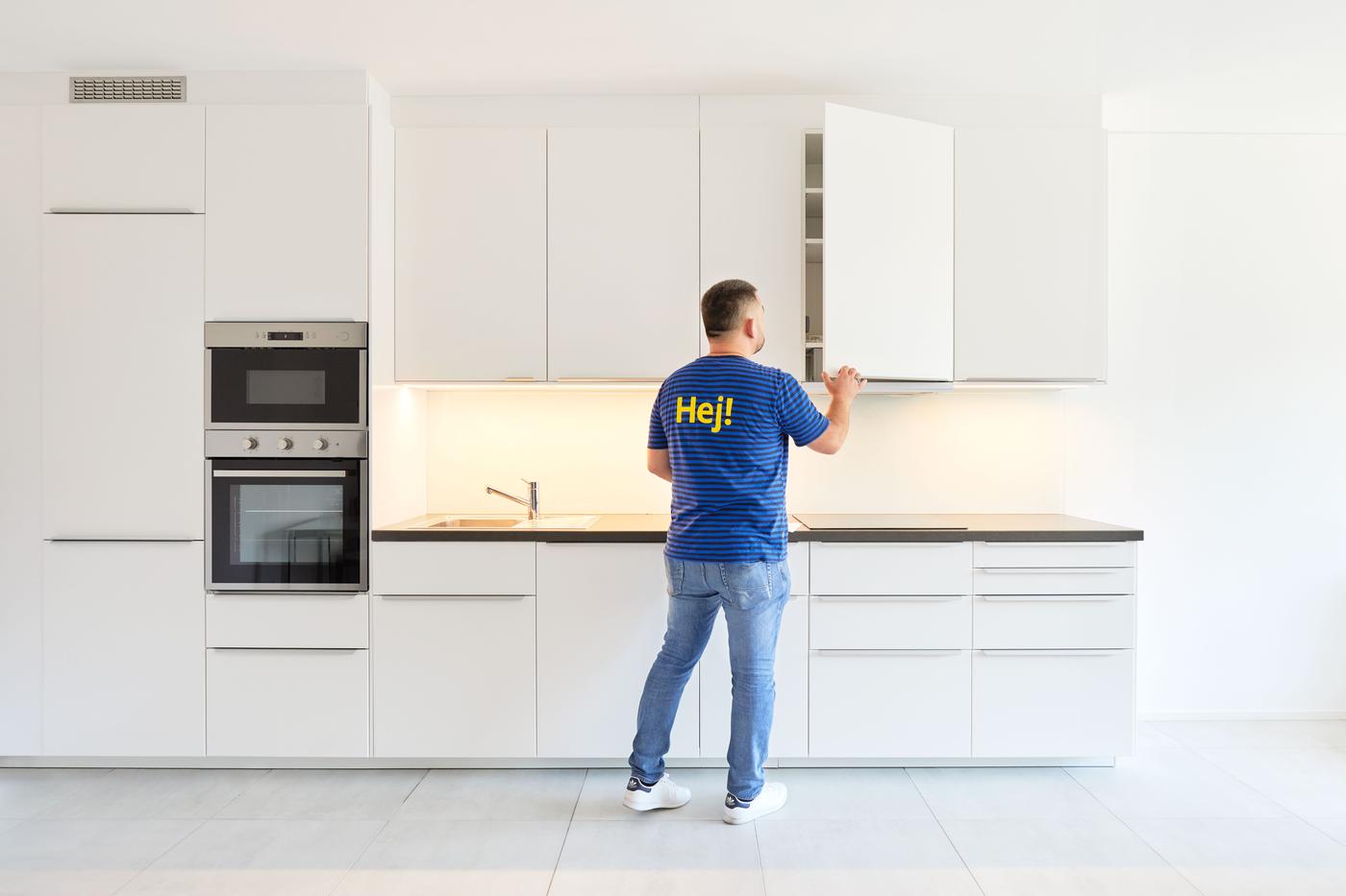 Due persone sono sedute a un tavolo da pranzo rotondo in una cucina di uno studio legale e conversano amichevolmente. Sul tavolo sono disposti degli snack e un bouquet di fiori in un vaso.