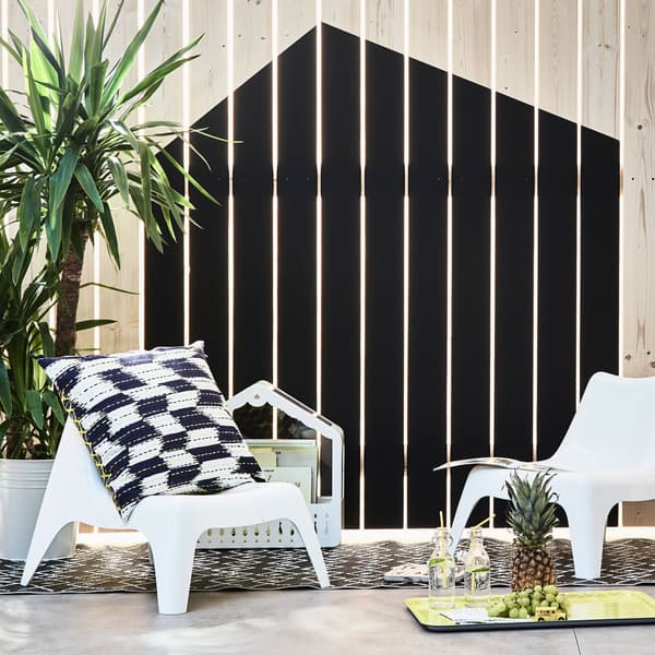 Due sedie per bambini vicino a uno steccato su cui è dipinta la forma di una casa - IKEA.