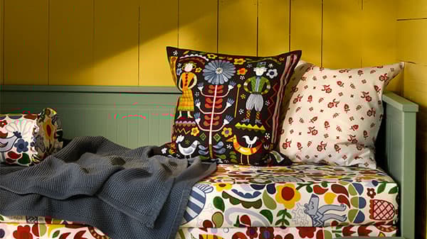 Dva polštáře na hraně rámu postele 