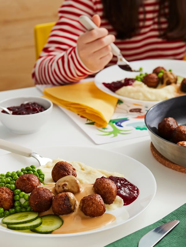 Dva talíře bezmasých kuliček HUVUDROLL s bramborovou kaší, hráškem, brusinkami a smetanovou omáčkou.