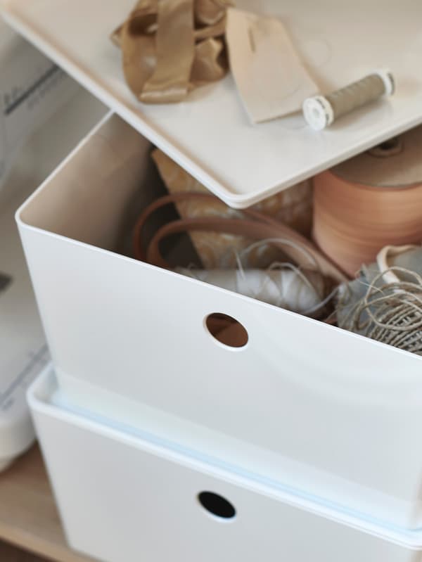 Dve biele škatule KUGGIS, jedna s pootvoreným vrchnákom.