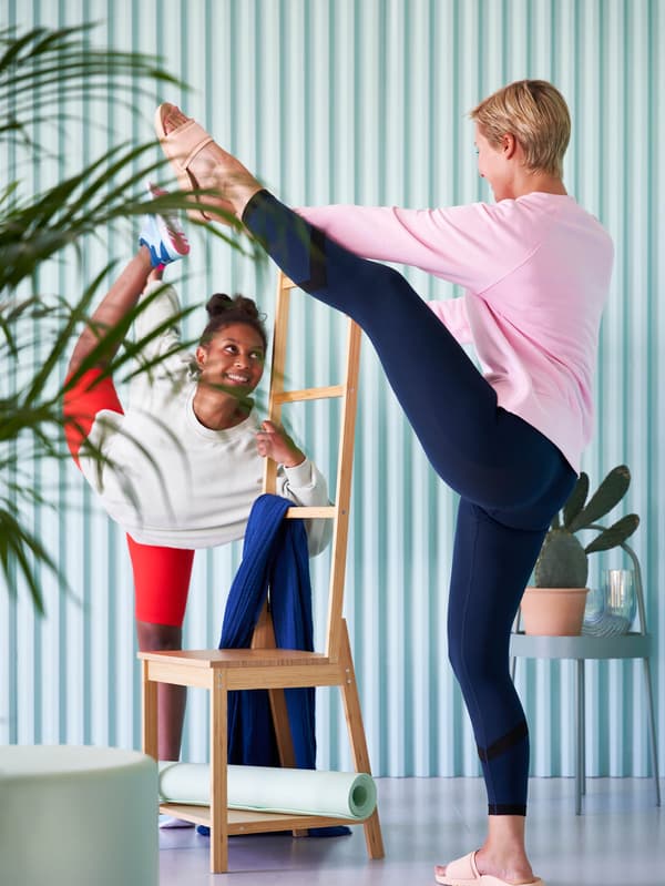 Dve dievčatá cvičia a pritom sa držia vešiaka na uteráky RÅGRUND. 