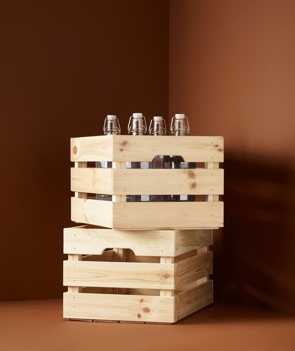 Dve úložné škatule z latiek z masívneho dreva uložené na sebe. Vo vrchnej škatuli sú uložené sklenené fľaše.