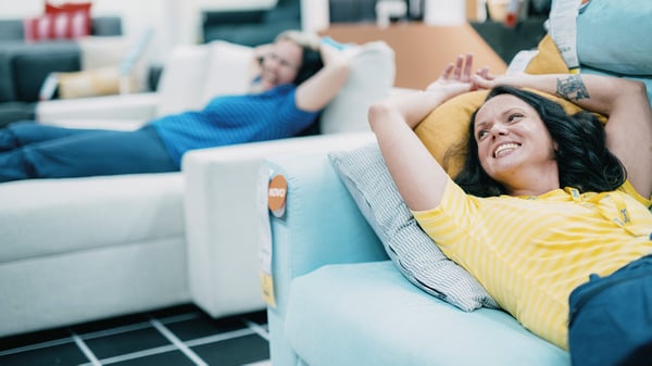 Dvoje ljudi leže na kaučima u robnoj kući