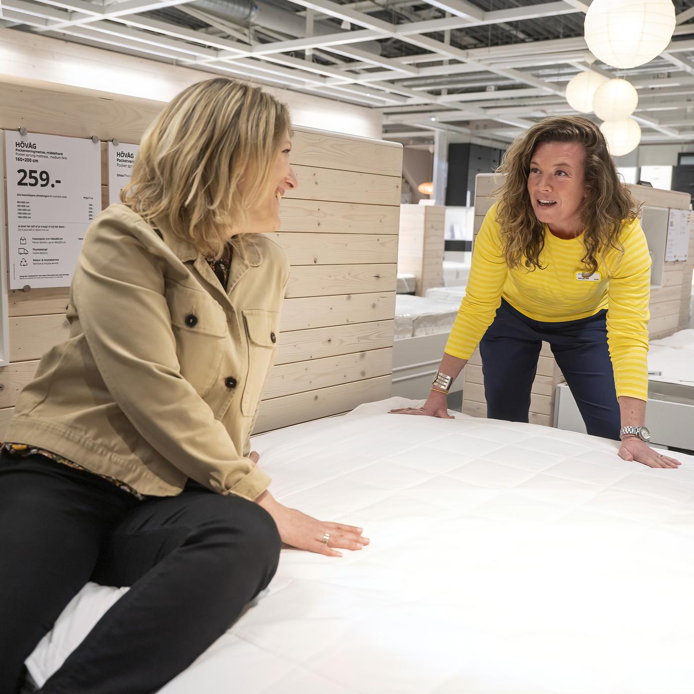 Dvoje ljudi pregledava madrac u robnoj kući IKEA.