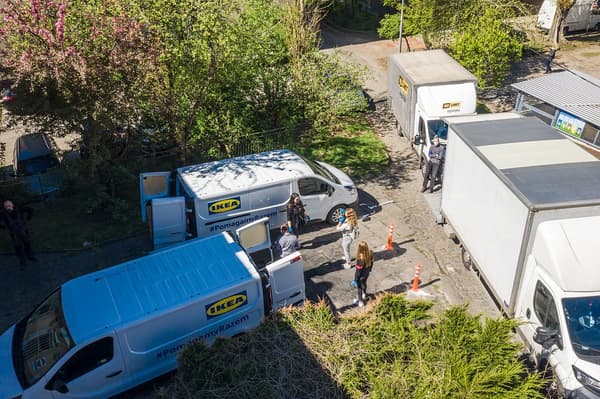 dwa samochody minivan i dwie ciężarówki z logo IKEA i napisem #PomagamyRazem