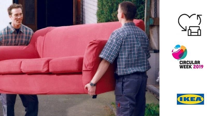 dwaj mężczyźni niosą dużą czerwoną sofę