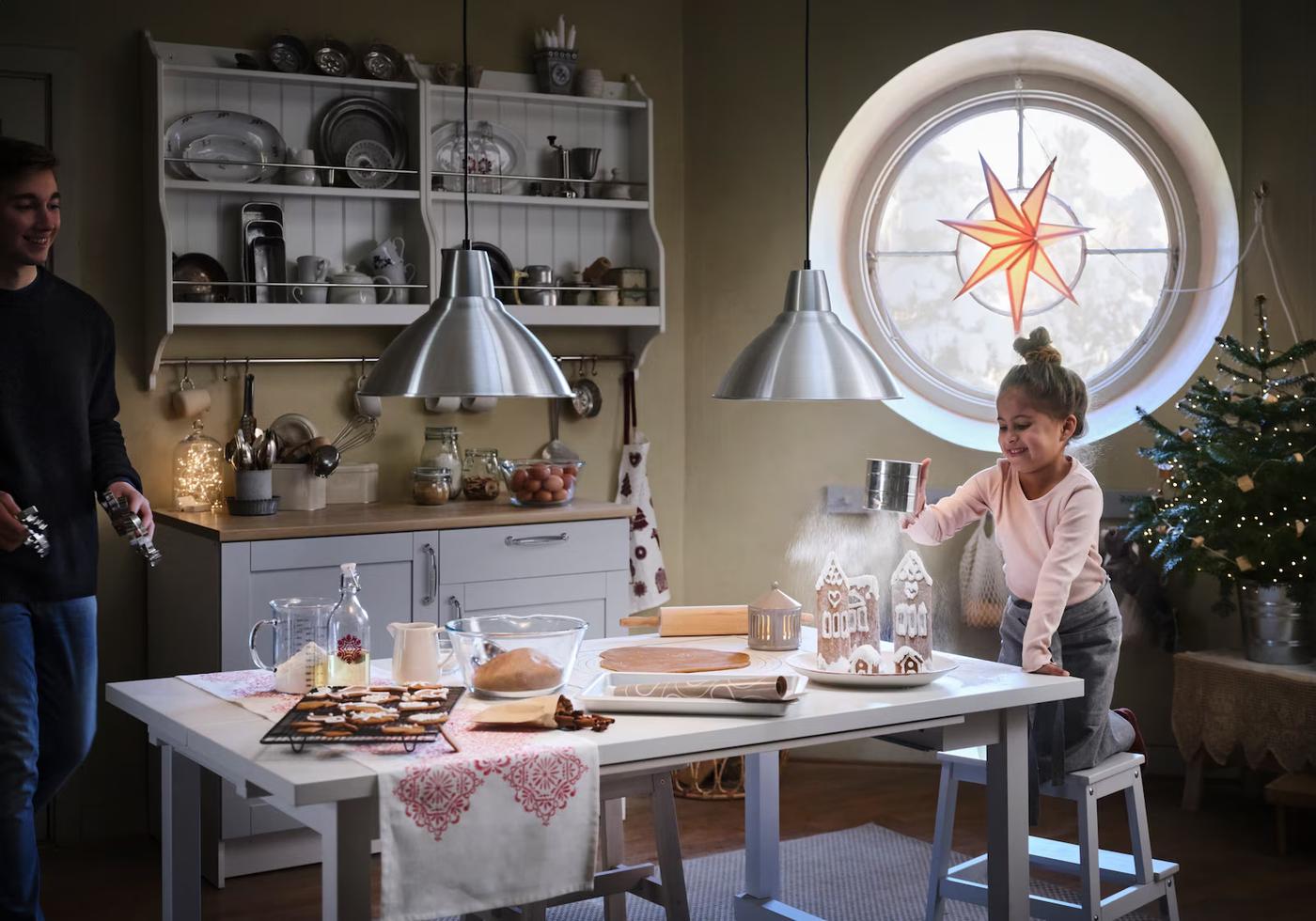 dwie osoby w kuchni dekorujące świąteczne pierniki