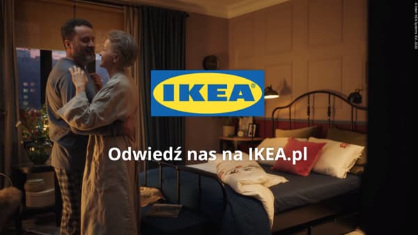 Dwie osoby w sypialni przytulają się. W tle łóżko oraz produkty IKEA.