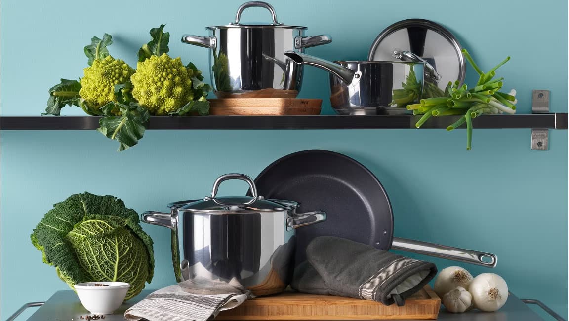 dwie półki kuchenne z garnkami i patelniami