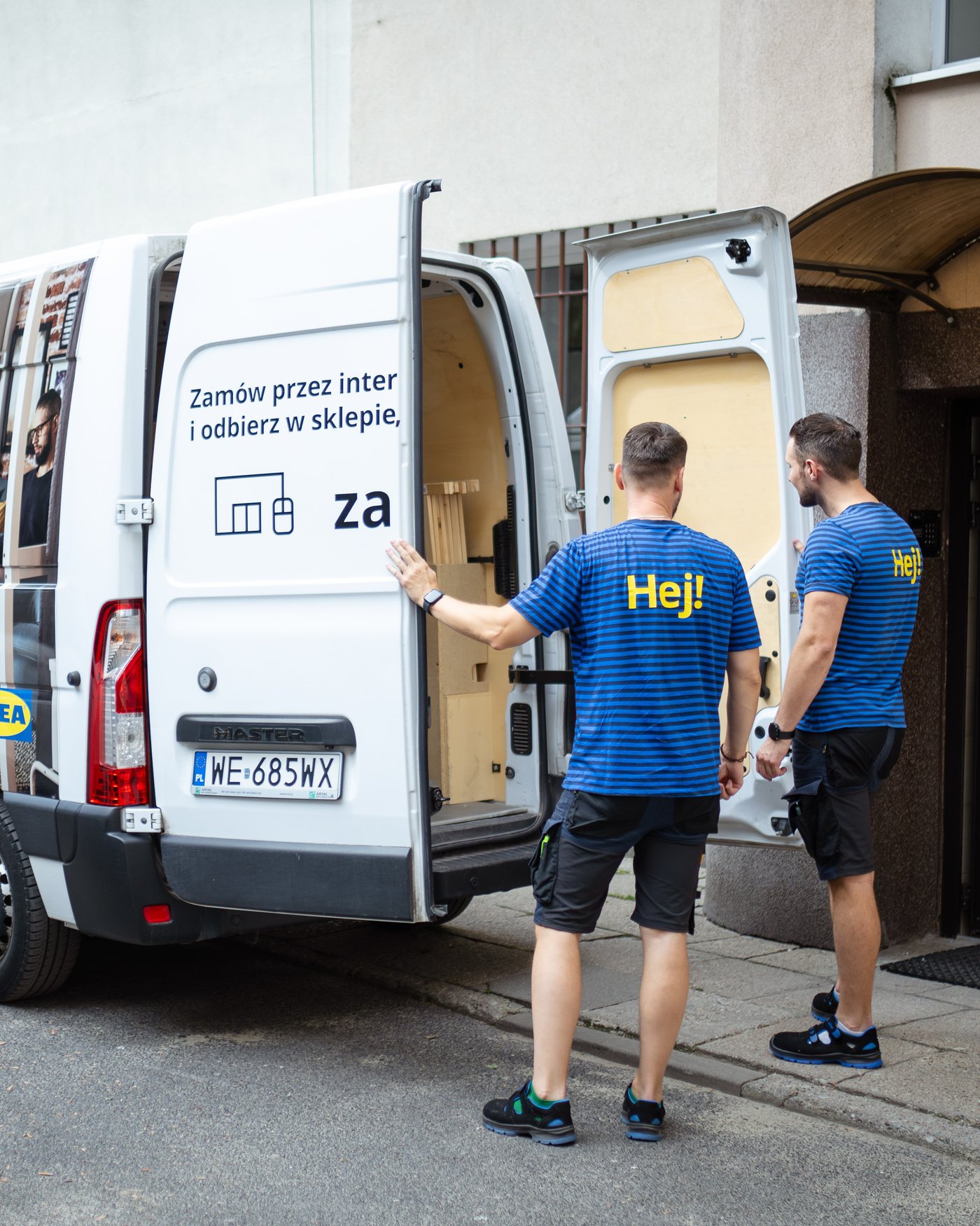 Dwóch pracowników IKEA przy samochodzie