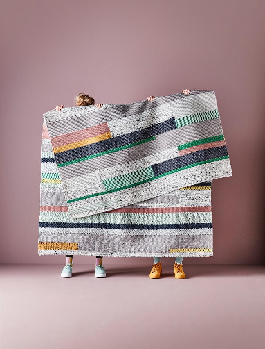 dwujka ludzi trzymająca dywan