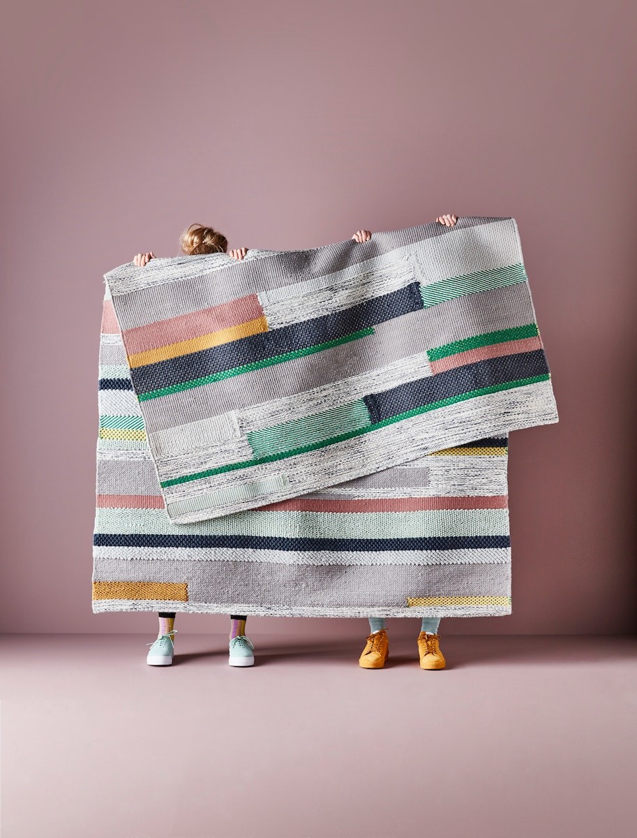 dwujka ludzi trzymająca dywan