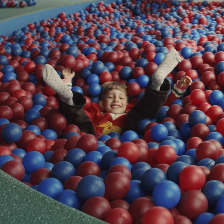 dziecko siedzące w kulkach