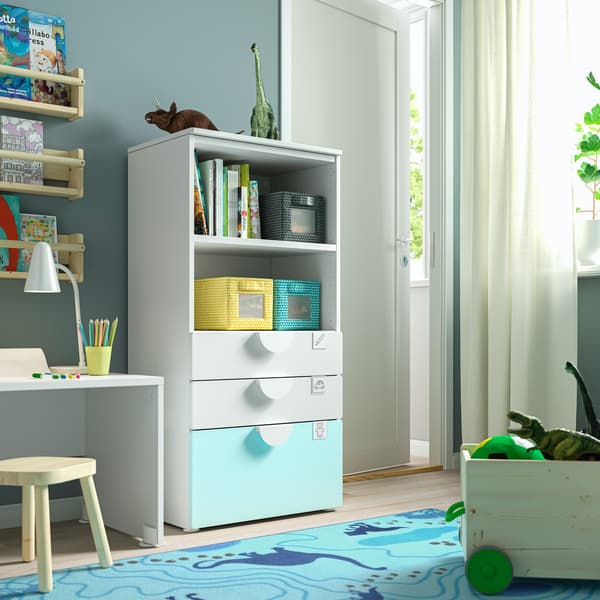 Een boekenkast met planken en lades in een kinderkamer.