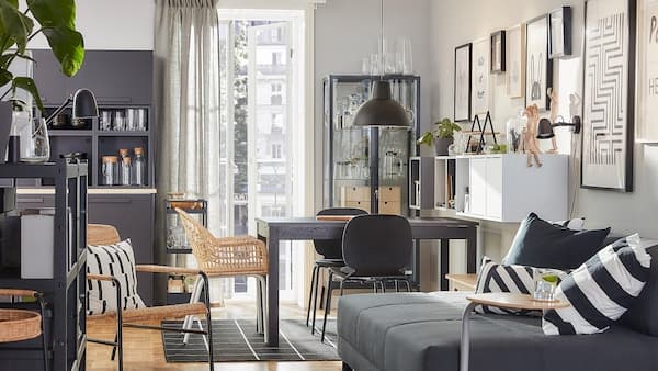 Een combinatie van eetkamer en woonkamer in dezelfde stijl met rotan meubels in de kleuren bruin, grijs en antraciet.