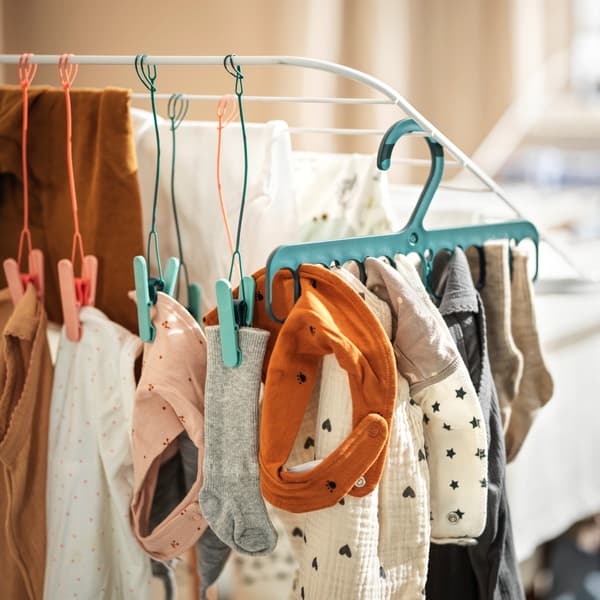 Een droogrek met SLIBB wasknijpers en hangers eraan met wasgoed.
