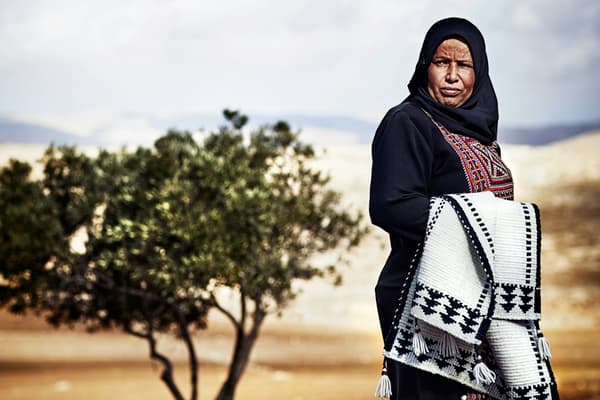 Een foto van Amneh Al Gawanmeh, een ambachtsman bij de Jordan River Foundation die meewerkt aan de TILLTALANDE collectie.