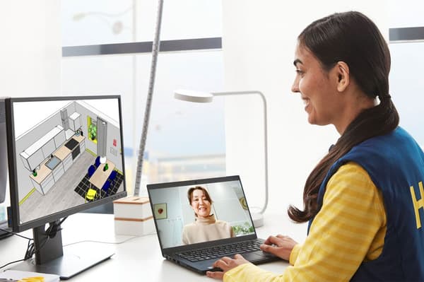 Een IKEA keukenspecialist heeft een computerscherm voor zich met een keukenplanner en praat met een klant online.