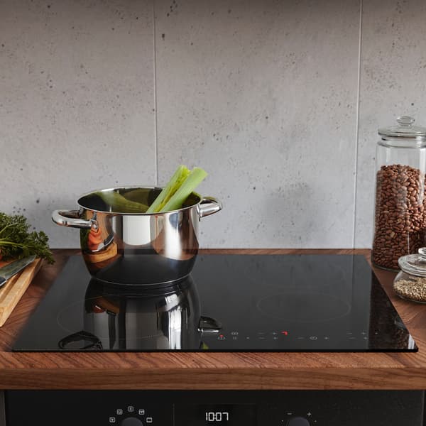 Een IKEA kookplaat met vier zones met een pan op de kookplaat.