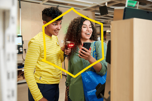 Een IKEA-medewerker in een geel shirt helpt een klant bij de kassa in de winkel.
