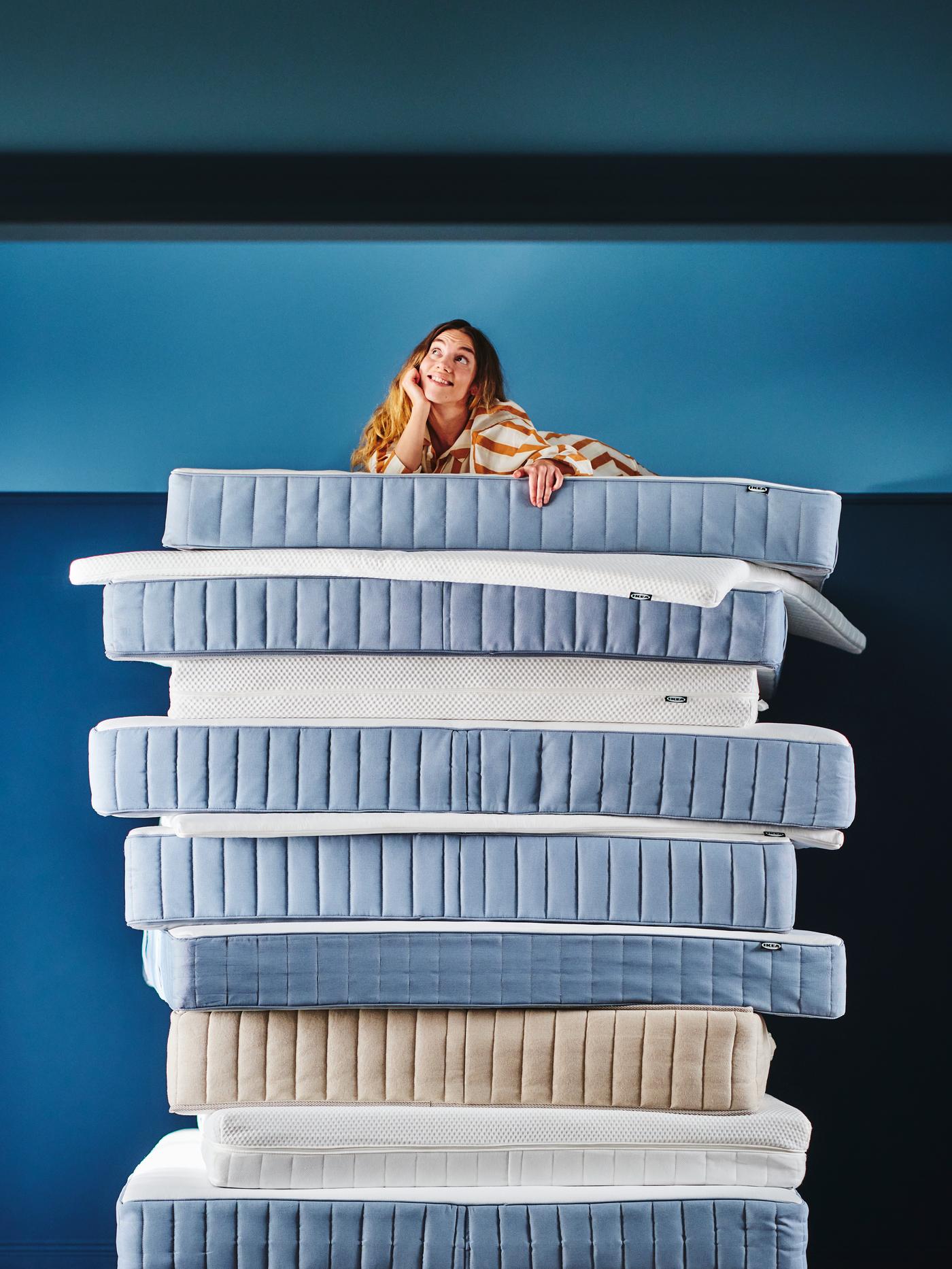 Een klant bovenop een stapel matrassen