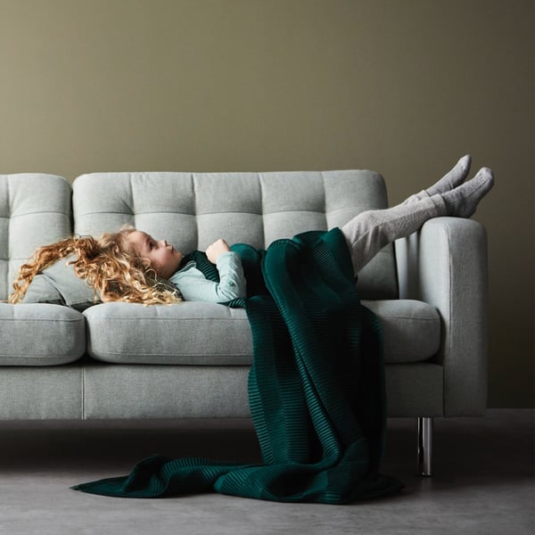 Een klein meisje ligt op de LANDSKRONA bank