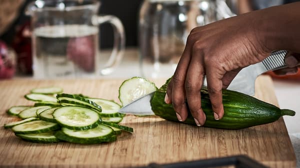 Een komkommer wordt gesneden door een mes uit de 365+ messenset