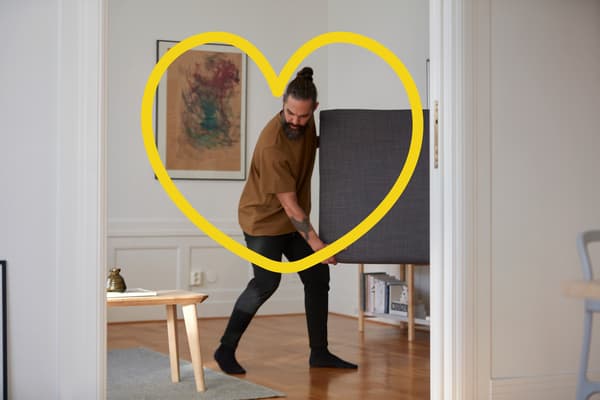 een man en een vrouw dragen samen een KALAX en steken een zebrapad over
