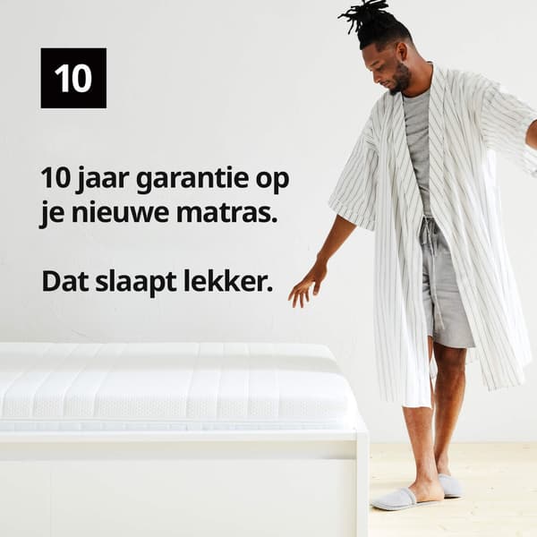 Een man in een badjas die naast een matras staat en een grafisch symbool met nummer 10 en de tekst '10 jaar garantie op je nieuwe matras. Dat slaapt lekker' op de afbeelding.
