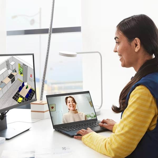 Een medewerker achter een laptop in gesprek met een klant