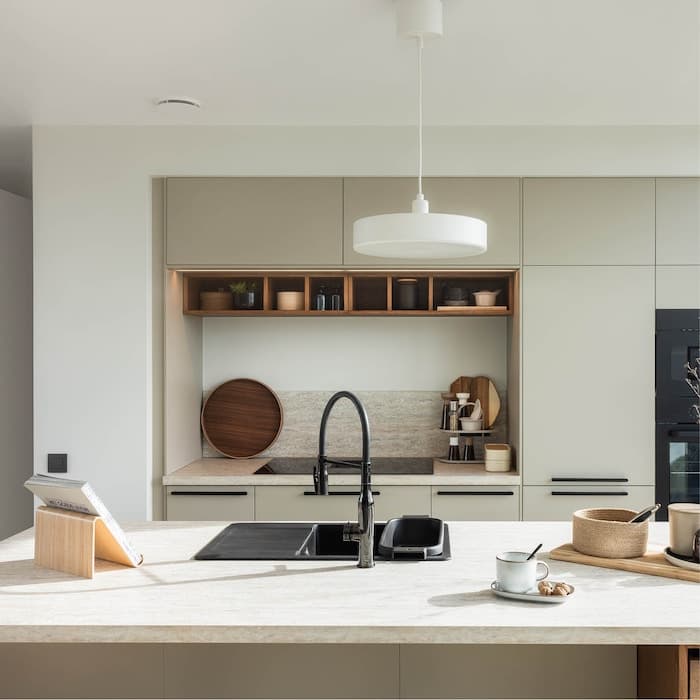 Een moderne keuken met een centraal eiland, een gootsteen en diverse keukengerei.