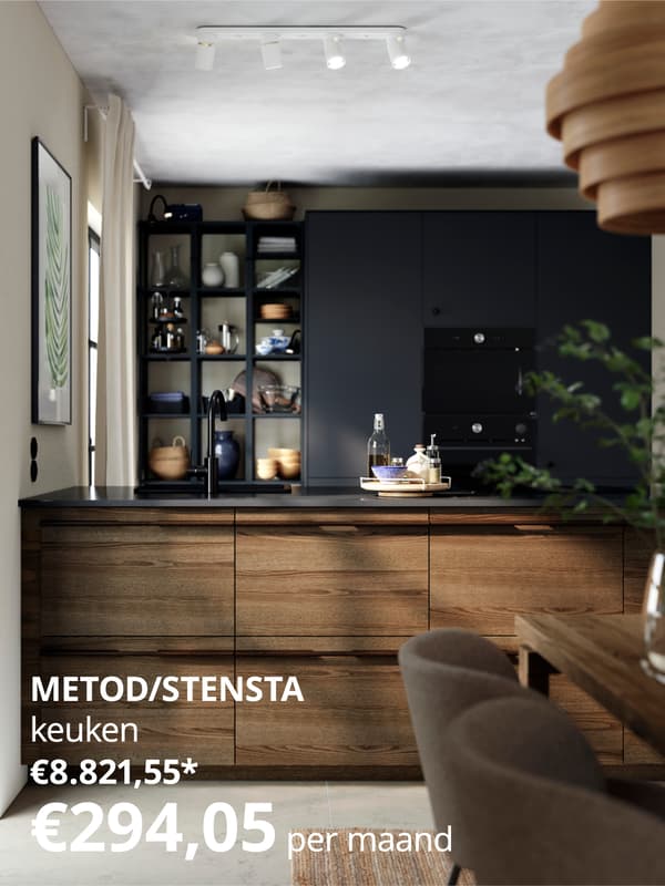 Een moderne keuken met houten kasten, een zwart aanrechtblad en open planken gevuld met keukengerei.