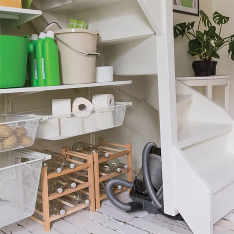 Een moeilijk hoekje van de trapkast  is de perfecte opbergplek voor je stofzuiger en wijnflessen.