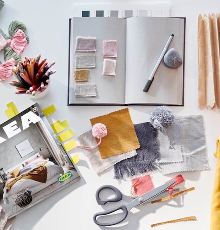 Een moodboard met een IKEA catalogus, schaar en een notitieboekje
