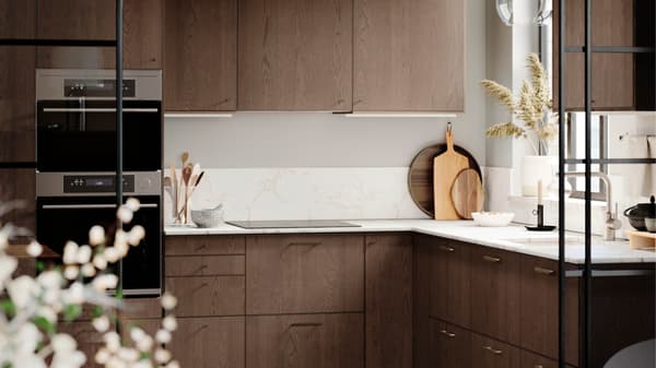 Een open keuken met ramen van de vloer tot het plafond, SINARP lades en deuren, zwarte hanglampen en barkrukken.