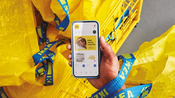 Een persoon houdt een telefoon vast met daarop de IKEA App