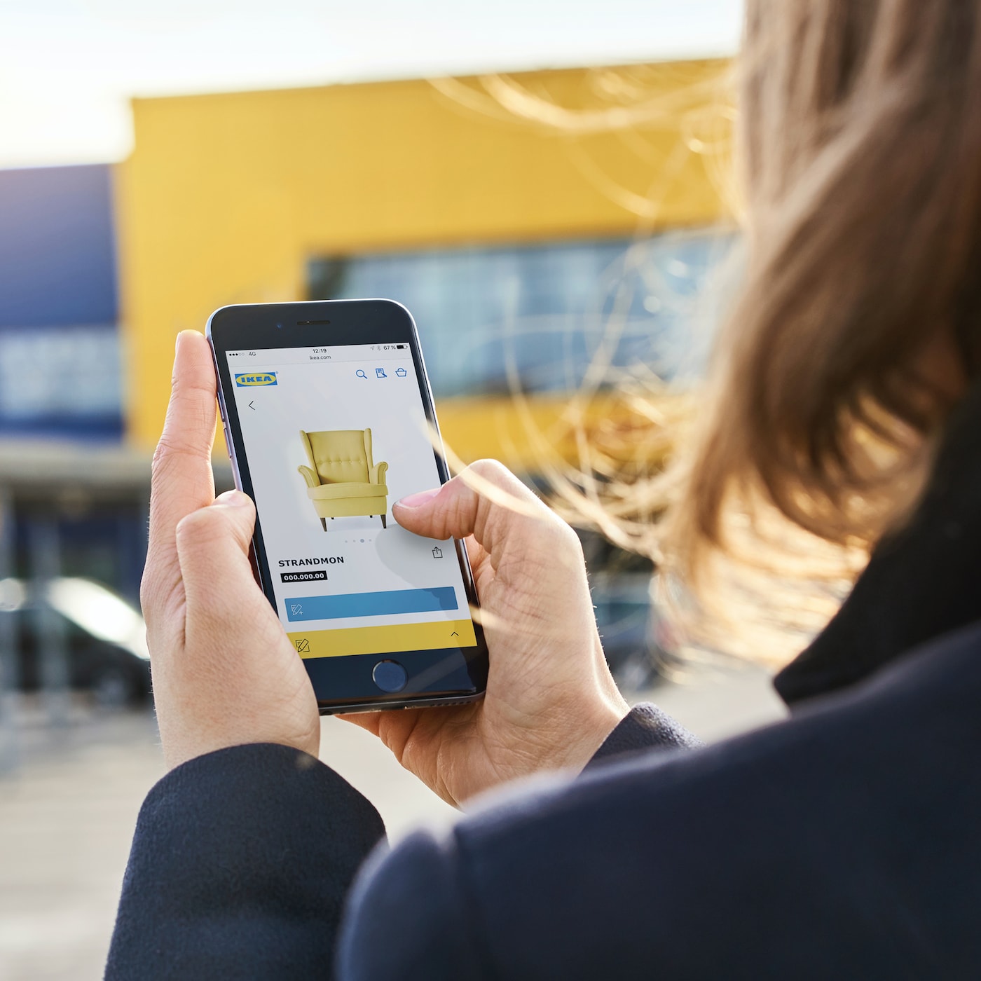 Een persoon met een telefoon met daarop de IKEA app