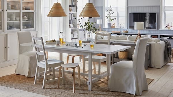 Een ruime en lichte eetkamer met een aangrenzende woonkamer. De eettafel is uitgeschoven en de krukken zorgen voor meer zitruimte.