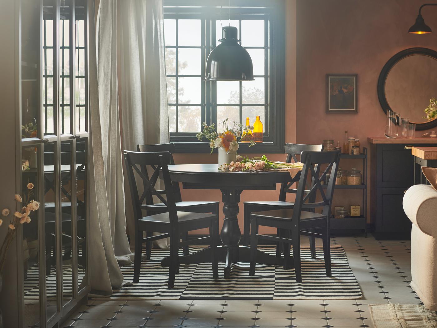 Een rustiek ogende eetruimte met roze wanden, een INGATORP uittrekbare tafel en vier INGOLF stoelen.