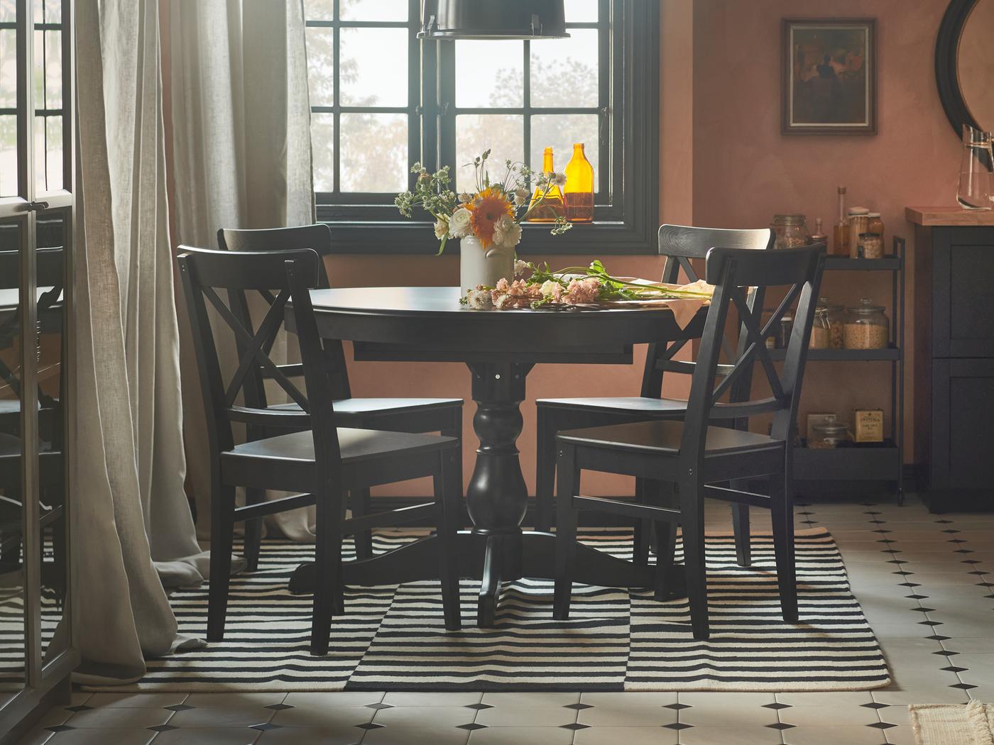 Een rustieke eetruimte met roze muren, een INGATORP uitschuifbare tafel en vier INGOLF stoelen.