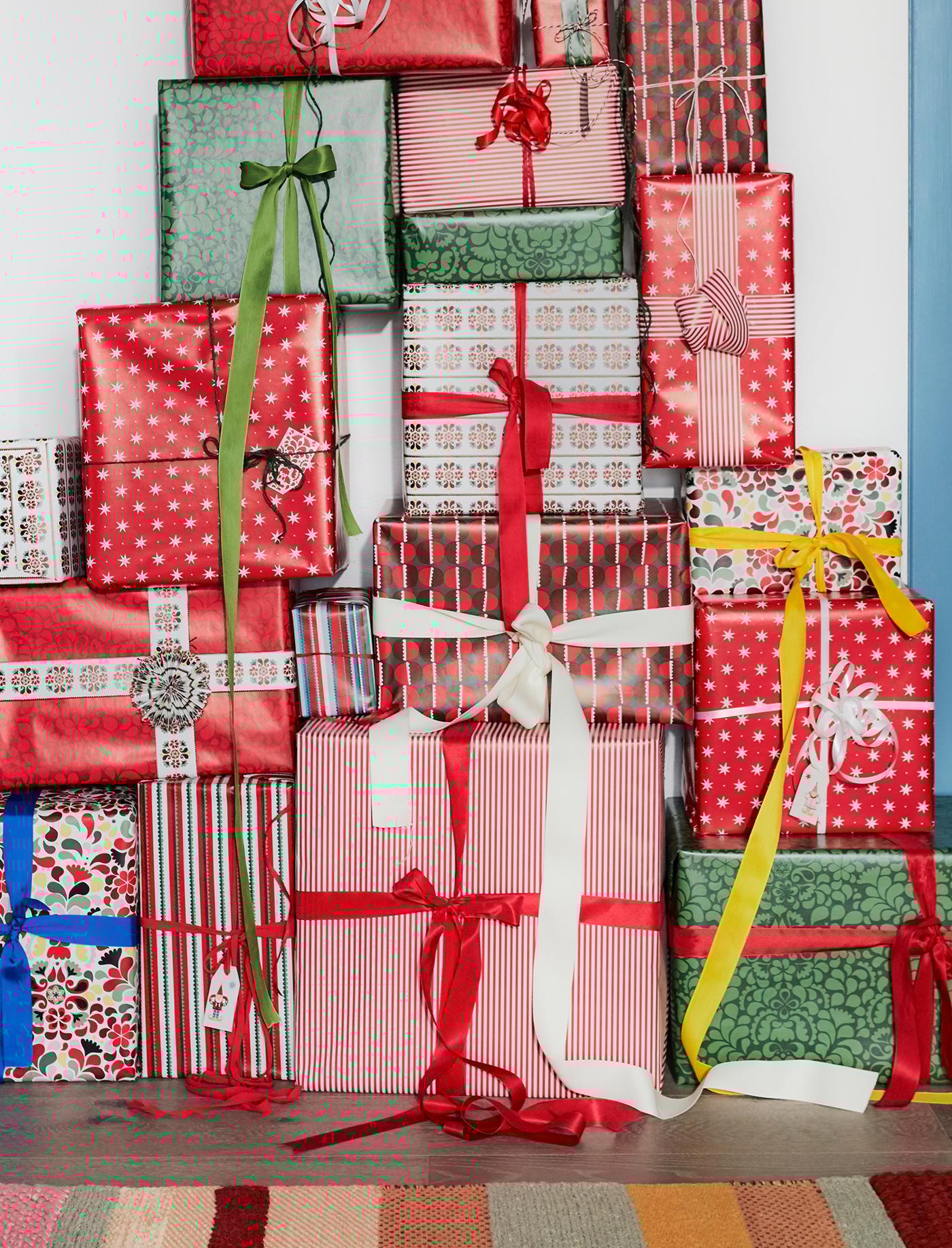 Een stapel van cadeaus die zijn ingepakt met kleurrijk cadeaupapier en cadeaulint.