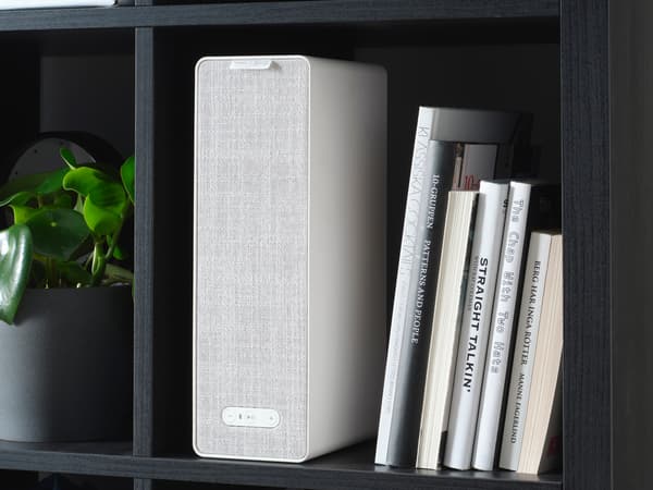 Een SYMFONISK boekenplankspeaker op een boekenplank, samen met een aantal boeken.