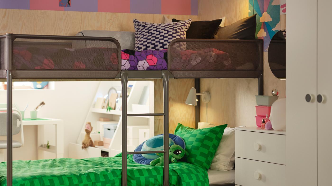 Een TUFFING stapelbed met twee verschillende looks. Het bovenste bed is opgemaakt met paars en roze en het onderste bed is blauw en groen.