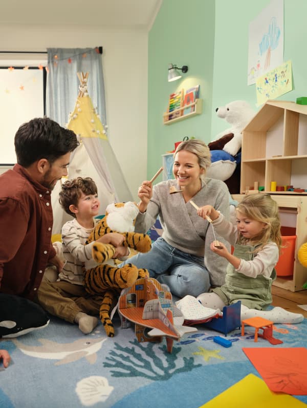 Een vader, moeder en twee kinderen spelen met IKEA-speelgoed