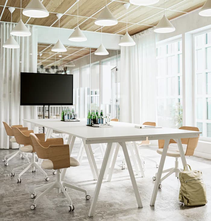 Een vergadertafel met 8 roze stoelen